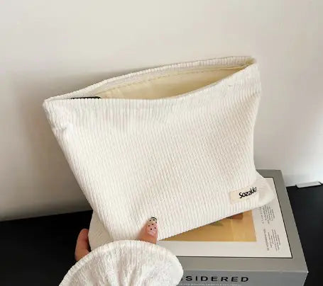 Stylish corduroy travel cosmetic bag and makeup organizer clutch. Perfect portable beauty bag for toiletries and essentials on the go.

